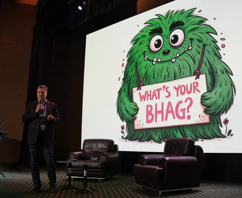 Harald Weinbrecht on stage next to a big screen that asks: What’s your BHAG?